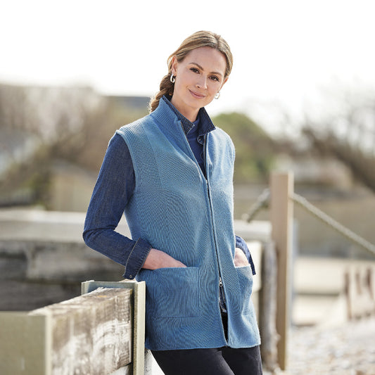 Woman wearing a cashmere blue zip-up vest outdoors with a blurred background
