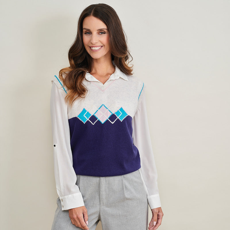 Woman wearing a cashmere long-sleeve shirt with a geometric pattern on a plain background