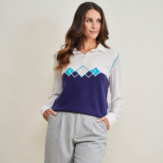 Woman wearing a cashmere long-sleeve shirt with a mountain design on a plain background