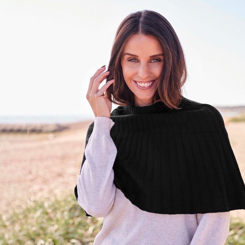Woman wearing a cashmere Black knitted cape outdoors