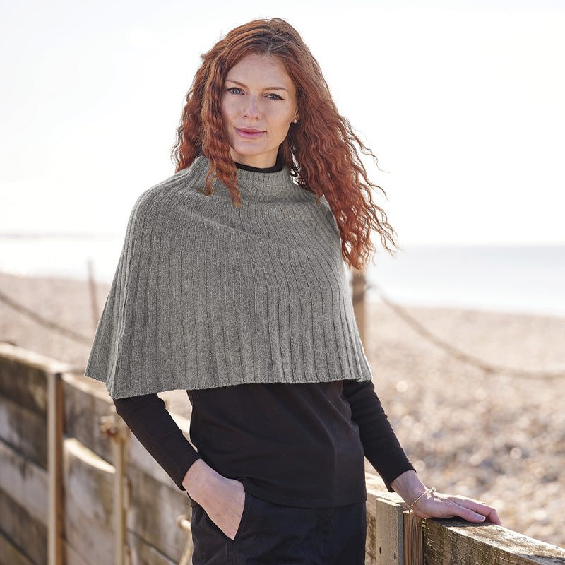 Woman wearing a cashmere grey knitted cape outdoors