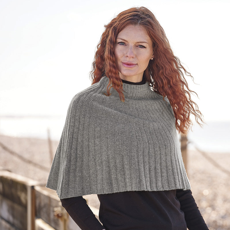 Woman wearing a cashmere grey knitted cape outdoors