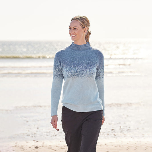 Woman wearing a blue gradient Cashmere sweater on a beach