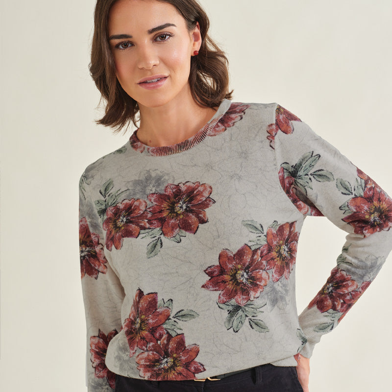 Woman wearing a Cashmere floral sweater against a plain background