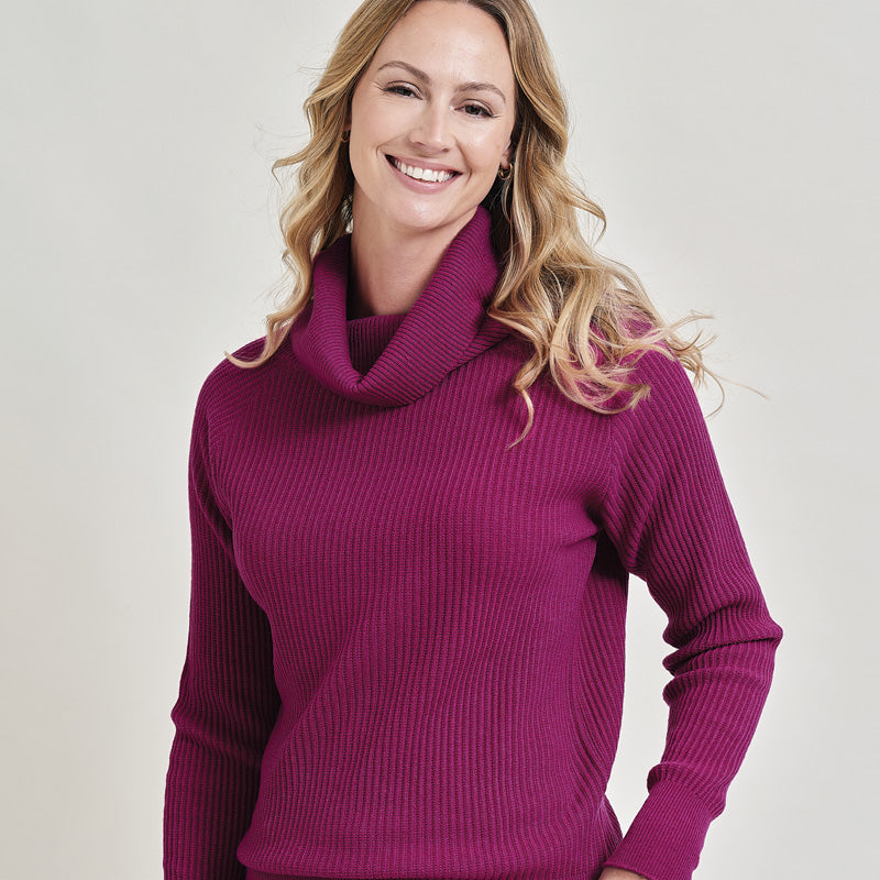 Woman wearing a cashmere purple turtleneck sweater on a plain background
