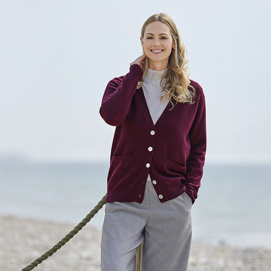 Woman wearing a cashmere maroon cardigan on a beach