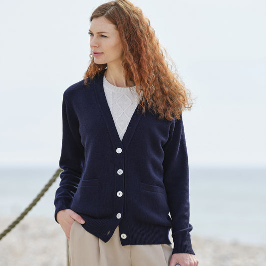 Woman wearing a cashmere navy cardigan on a beach