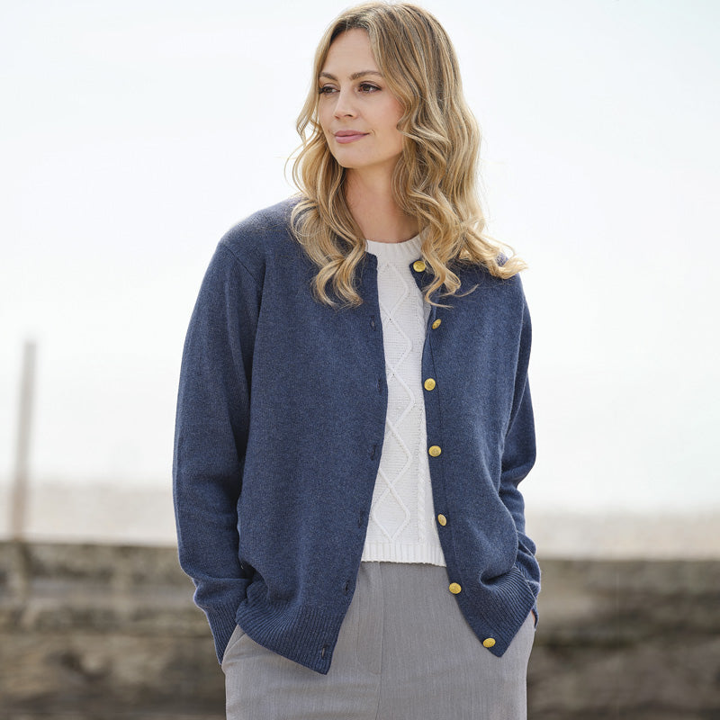 Woman wearing a cashmere denim blue cardigan with yellow buttons outdoors