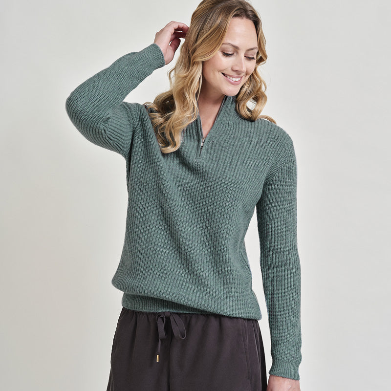 Woman wearing a cashmere green sweater on a plain background