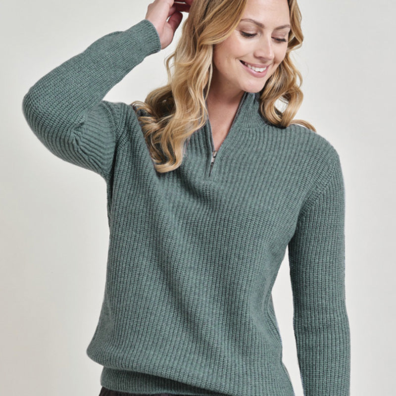 Woman wearing a cashmere green sweater against a plain background