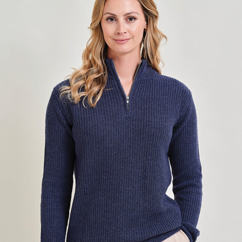 Woman wearing a cashmere denim blue ribbed sweater against a plain background